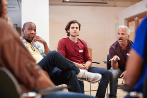 People sitting in a circle at a men's rehab program session